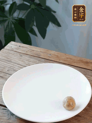 做水油皮、油酥 將油皮材料放入料盆中，加100ml水?dāng)嚢璩裳┗ㄆ瑺?。在案板上反?fù)揉搓成有一定筋度的光潔面團，搓成14個團子。
